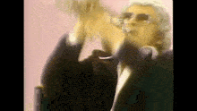 a blurry picture of a man in a suit and sunglasses