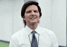 a man in a white shirt and tie is holding a red ball in his hands