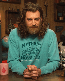 a man wearing a mythical move lub shirt