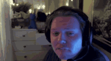 a man wearing headphones is sitting in front of a computer screen .