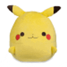 a yellow stuffed animal with a brown tail and ears is sitting on a white surface .