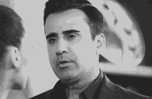 a man in a suit and tie is standing in front of a woman .