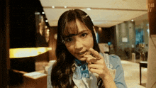a girl with a ring on her finger is wearing a blue and white dress