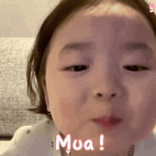 a close up of a baby 's face with the word mua written on it