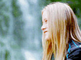 a woman with long blonde hair is wearing a blue shirt