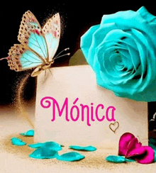 a butterfly is sitting on a card with the name monica written on it .