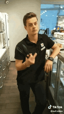 a man wearing a 7 eleven shirt holds a spatula