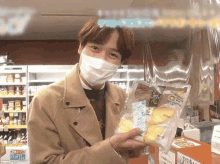 a man wearing a face mask is holding a bag of bread