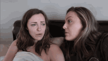 two women are looking at each other with one wearing a black shirt that says ' i love you ' on it