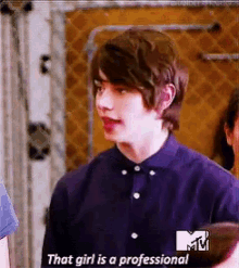 a young man in a purple shirt is talking about a girl who is a professional .