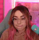 a girl with pink hair wearing glasses and headphones making a funny face