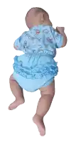 a baby wearing a blue shirt with animals on it is laying on its back