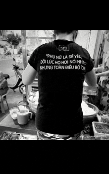 a black and white photo of a woman wearing a t-shirt that says " phụ nữ là đề yêu "
