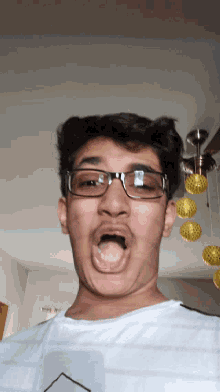 a man with glasses making a funny face with his mouth open