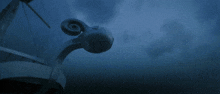 a statue of a ram with a spiral on it stands in front of a blue sky