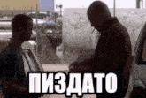 two men are shaking hands in front of a car in a parking lot with a sign that says ' пиздато ' on it