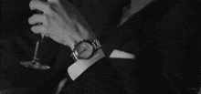 a black and white photo of a man wearing a watch on his wrist