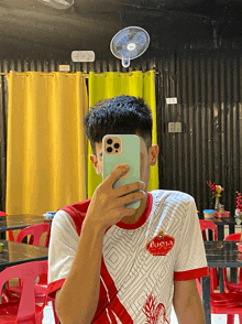 a man taking a picture of himself with a buena shirt on