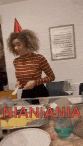 a woman wearing a party hat is standing in front of a table with the word nianiania written in red