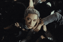 a man with white hair is surrounded by a crowd of people