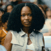 a woman sitting in a crowd with a netflix logo on the bottom