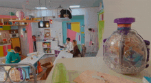 a group of people are sitting around a table in a colorful room with a bottle that says ' r ' on it