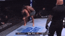 two men are fighting in a boxing ring while a referee watches .