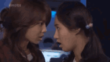 two women are standing next to each other and looking at each other .