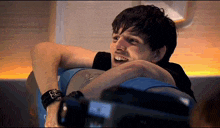 a man with a watch on his wrist is laughing while holding another man