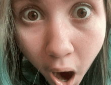 a close up of a woman 's face with a surprised expression
