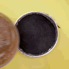 a pan filled with black powder is being poured into another pan