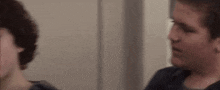 a man and a woman are standing next to each other in a room and talking to each other .