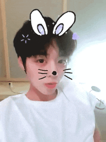 a young boy wearing a white t-shirt with a cat face on his face