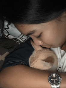 a woman wearing a bulova watch holds a cat in her arms