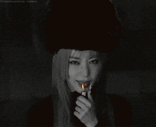 a black and white photo of a woman lighting a lighter with clubclassics tumblr in the corner