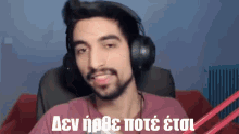 a man wearing headphones and a pink shirt with a foreign language written on the bottom