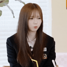 a girl in a school uniform has a badge on her jacket that says ' jc ' on it