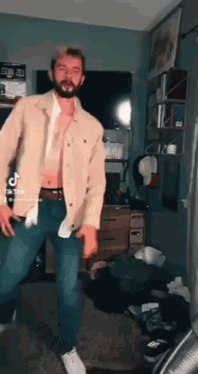 a man with a beard is dancing in a living room .