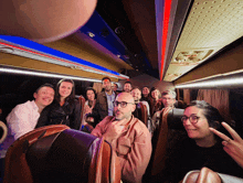 a group of people are sitting on a bus and one of them has glasses on