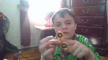 a boy holding a fidget spinner with the word tnt on his shirt