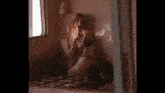 a woman sitting on a bed looking at herself in a mirror .