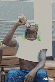 a man with green hair is drinking from a bottle that says jack daniels on it