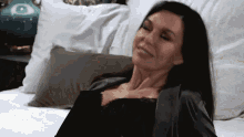 a woman in lingerie is laying on a bed with white sheets