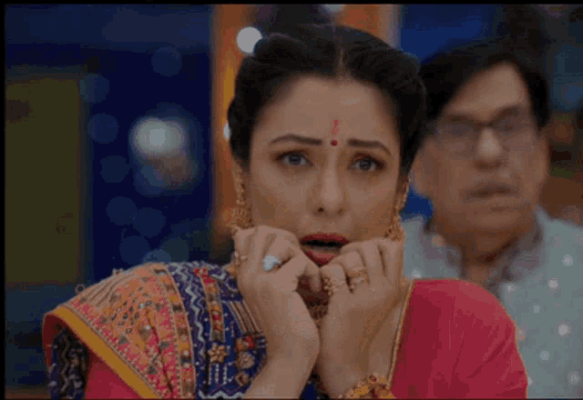 a woman with a red bindi on her forehead is making a surprised face