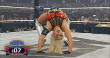 a female wrestler is doing a handstand in a wrestling ring
