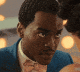 a man in a blue suit and pink bow tie