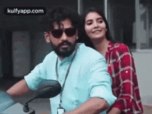 a man and a woman are riding a motorcycle together and the woman is hugging the man .