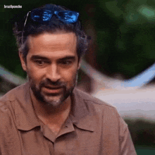a man with a beard wearing sunglasses and a brown shirt with the hashtag brazilponcho