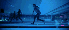 a man is running down a bowling alley with a neon sign that says ' bowling '