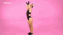 a woman wearing bunny ears is holding an eggplant in her hair .